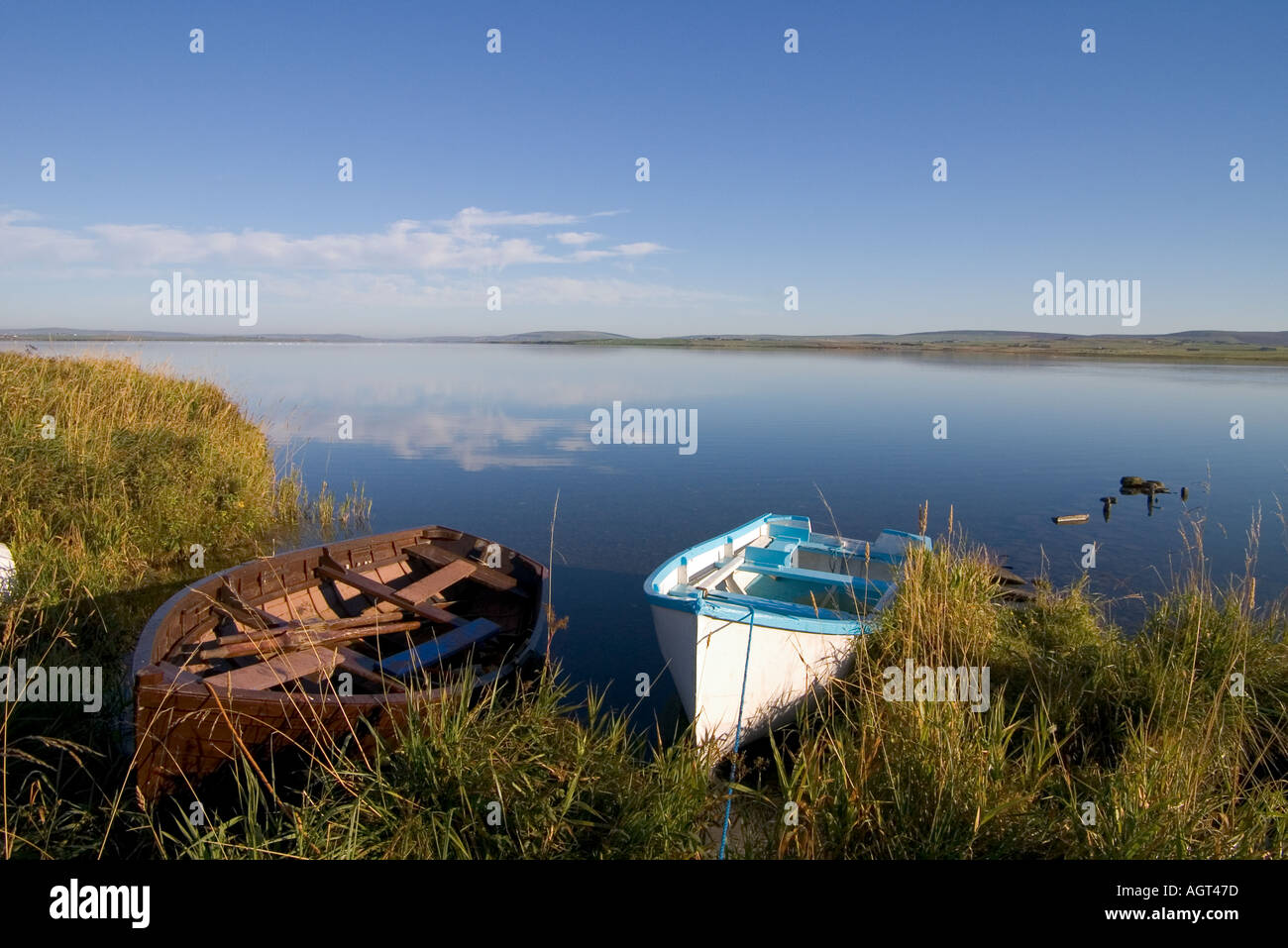 dh Loch of Harray STENNESS ORKNEY Fishing boats beach on grassy shore rowing boat quiet scotland Stock Photo