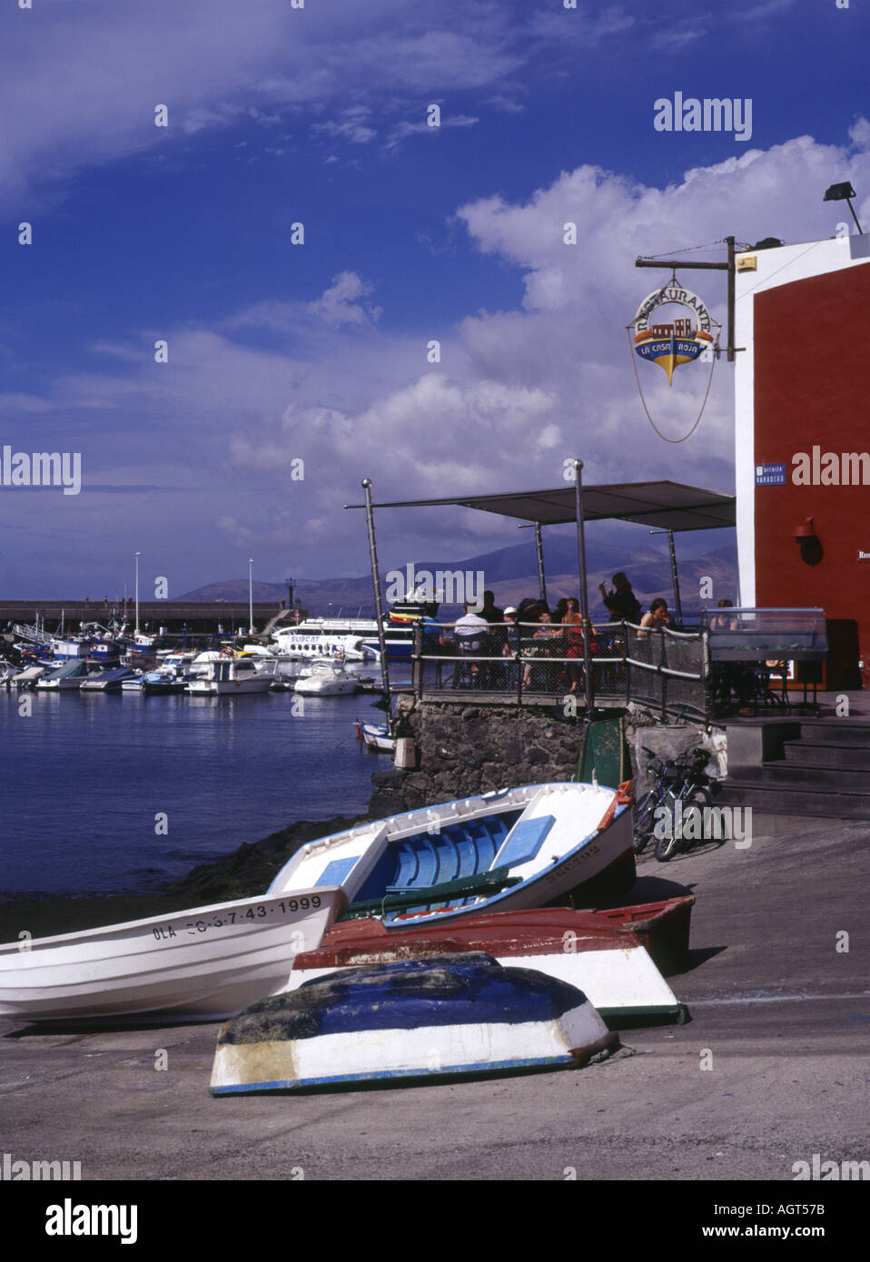 dh  PUERTO DEL CARMEN LANZAROTE Small boats on slipway tourists eating out balcony harbour restaurant cafe Stock Photo