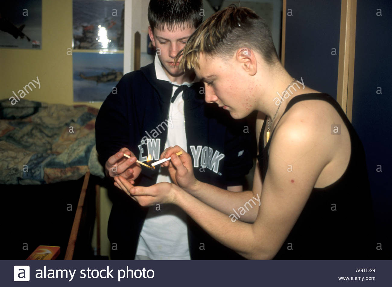 Teenage boys smoking cigarettes in bedroom at home uk