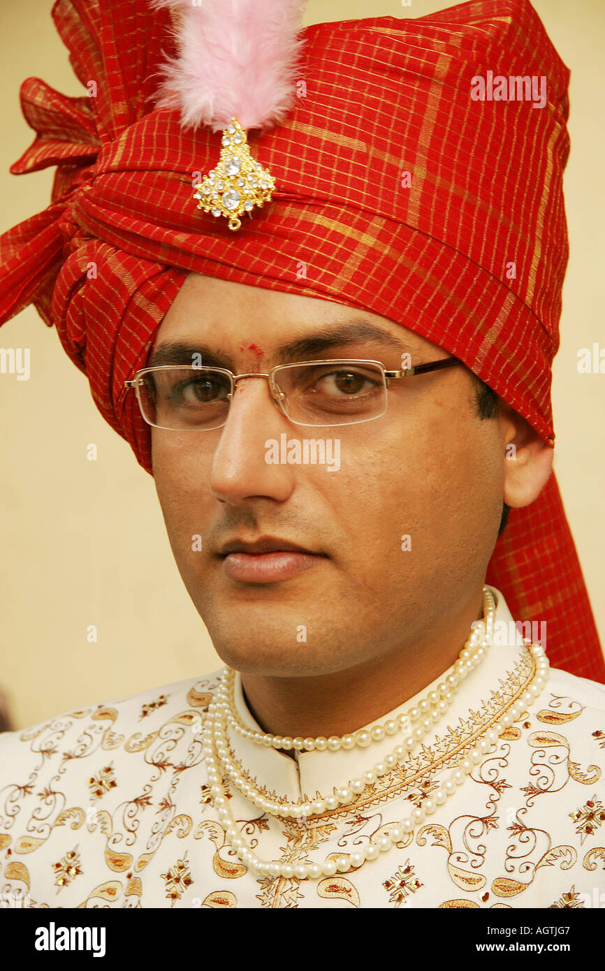 Indian Gujarati Bridegroom wearing turban with broach and embroidered coat called Sherwani and necklace of pearls on wedding day Stock Photo
