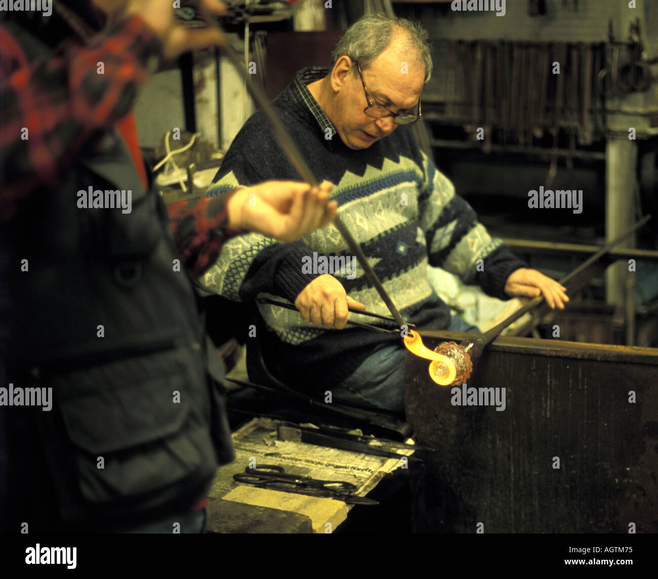 Glass blower at his furnace in Murano glass works Venice Italy Stock