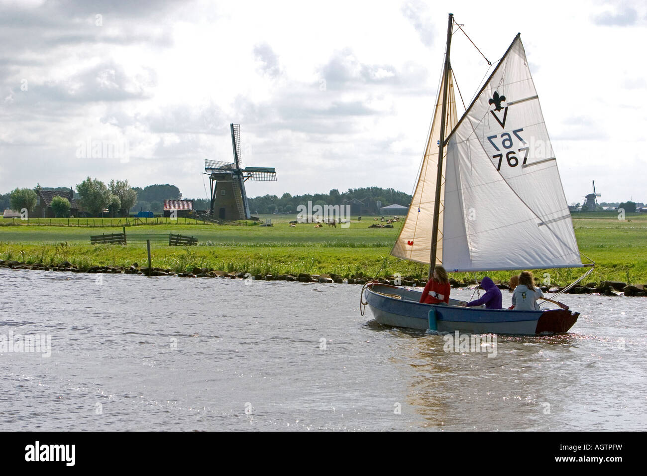 Sailing past a windmill on a canal east of Leiden in the province of South Holland Netherlands Stock Photo