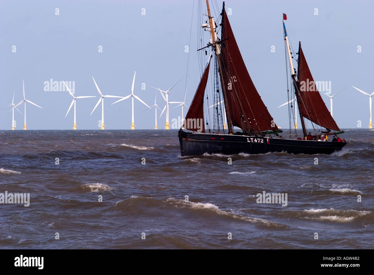 old fishing boat sails past gt yarmouth wind farm Stock Photo Alamy