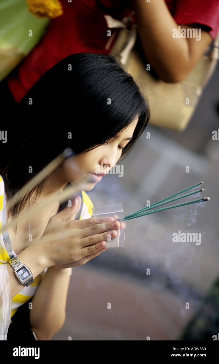 Young Thai woman prays at Eriwan Buddhist Shrine near Siam Sqaure in Bangkok Thailand  Stock Photo