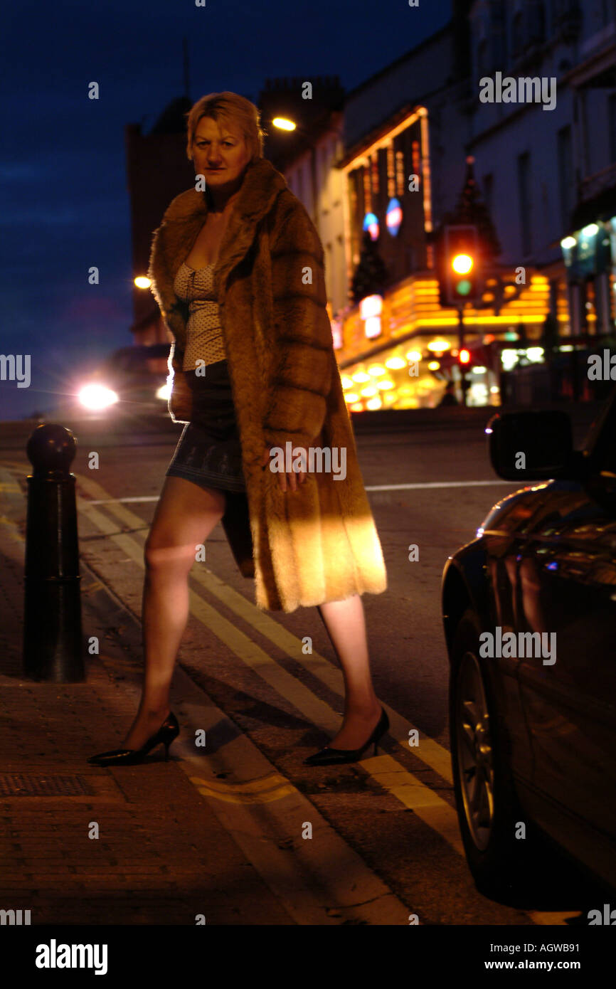 female call girl prostitute operating in red light district approaching car  driver Stock Photo - Alamy