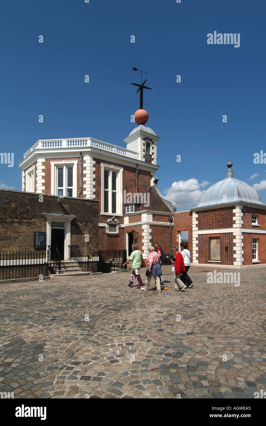 Group of people in courtyard in Greenwich Observatory & lowered red historical Time Ball above Flamstead House beyond Greenwich Park London England UK Stock Photo