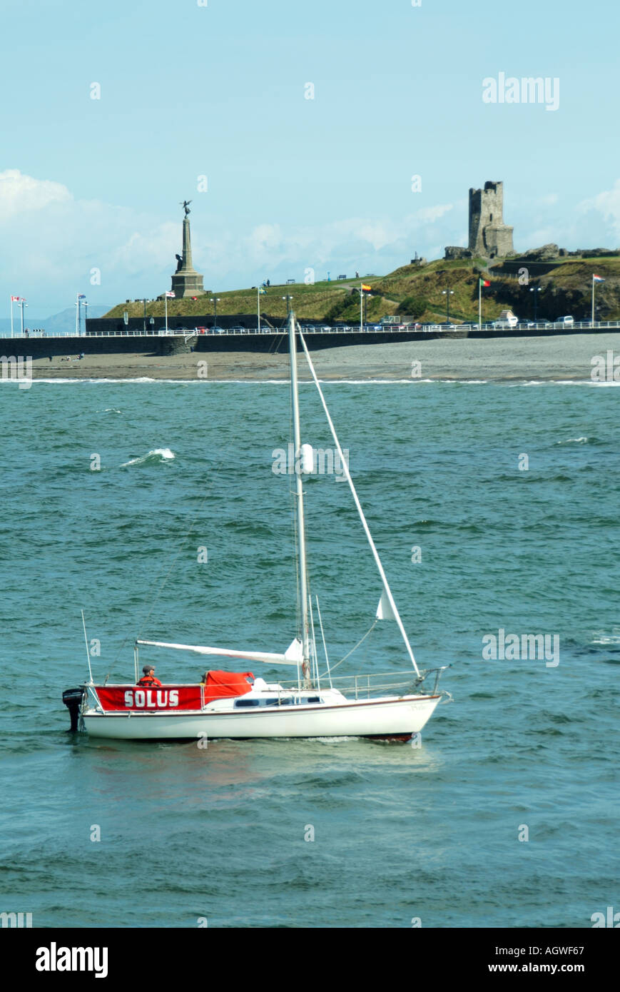 Irish sea sailing yacht approaching Aberystwyth coastline & harbour with war memorial & tall