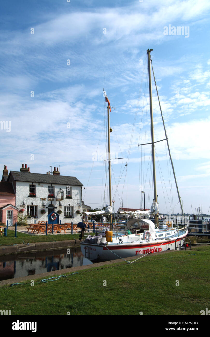 Heybridge Basin River Blackwater yacht waiting at lock gates for high tide entry to the tidal estuary The Old Ship inn beyond Stock Photo