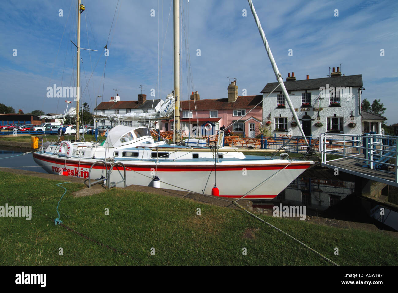 Heybridge Basin yacht waiting at lock gates for high tide entry to the River Blackwater tidal estuary The Old Ship inn beyond Essex England UK Stock Photo