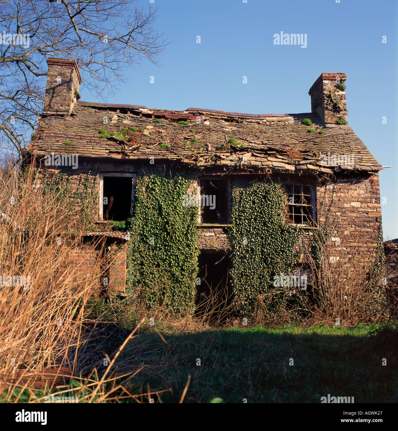 Derelict abandoned old stone house cottage with loose roof tiles Wales, UK KATHY DEWITT Stock Photo