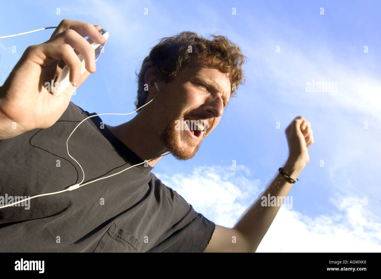 Young man singing loudly with his ipod mp3 player Stock Photo