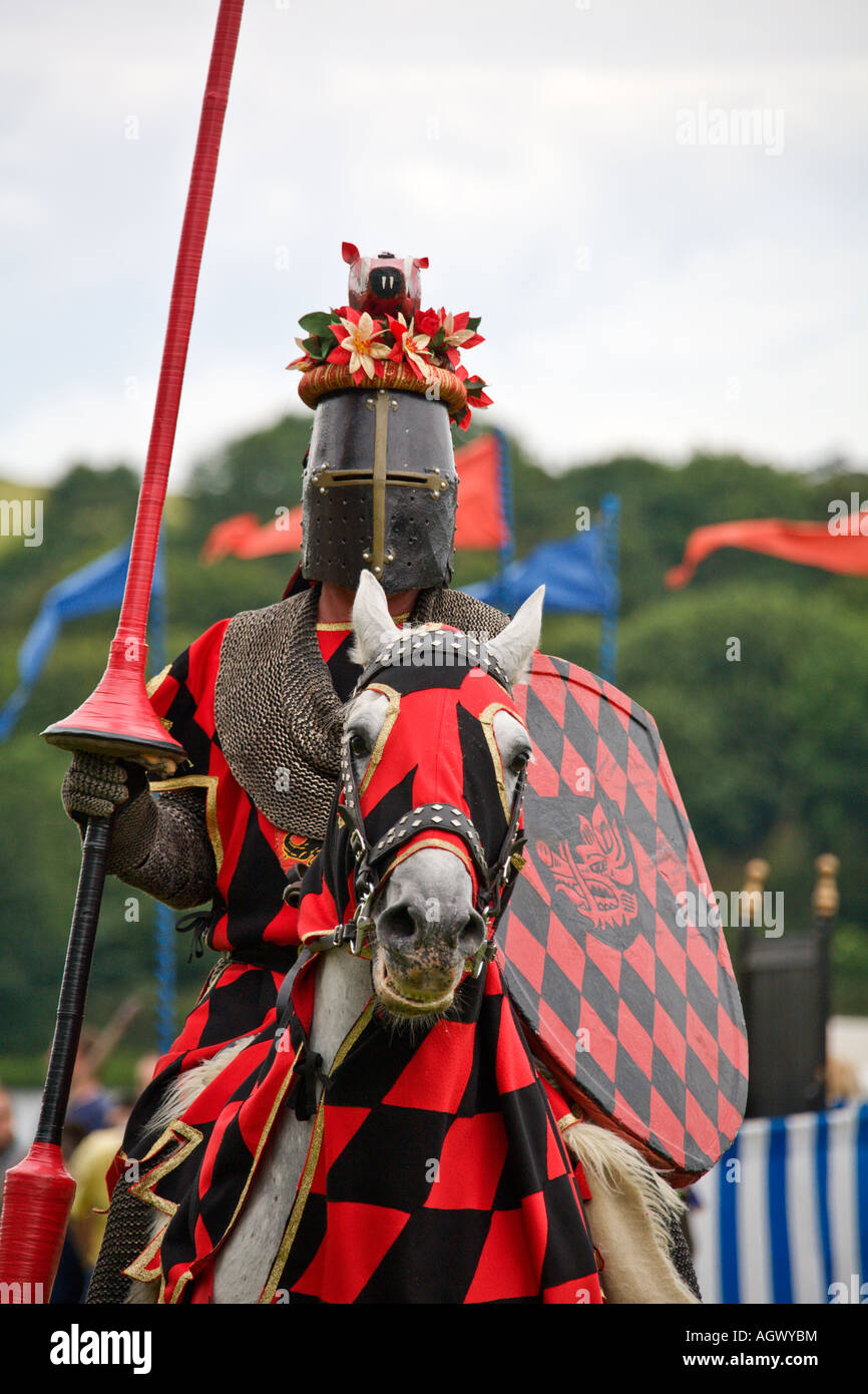 Medieval knight on horseback holding lance and shield during reenactment tournament Stock Photo