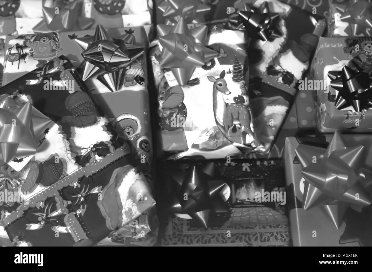 A close view background of wrapped Christmas presents. A variety of gift paper, tags and bows are visible. Stock Photo