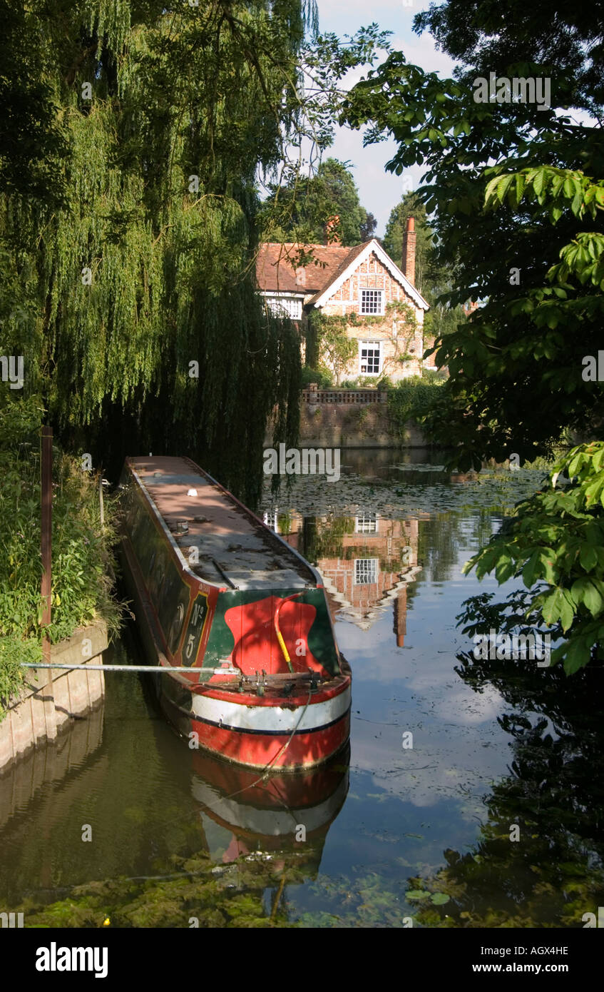 A traditional canal longboat tied up on a quiet backwater of the River Thames at Goring in Oxfordshire Stock Photo