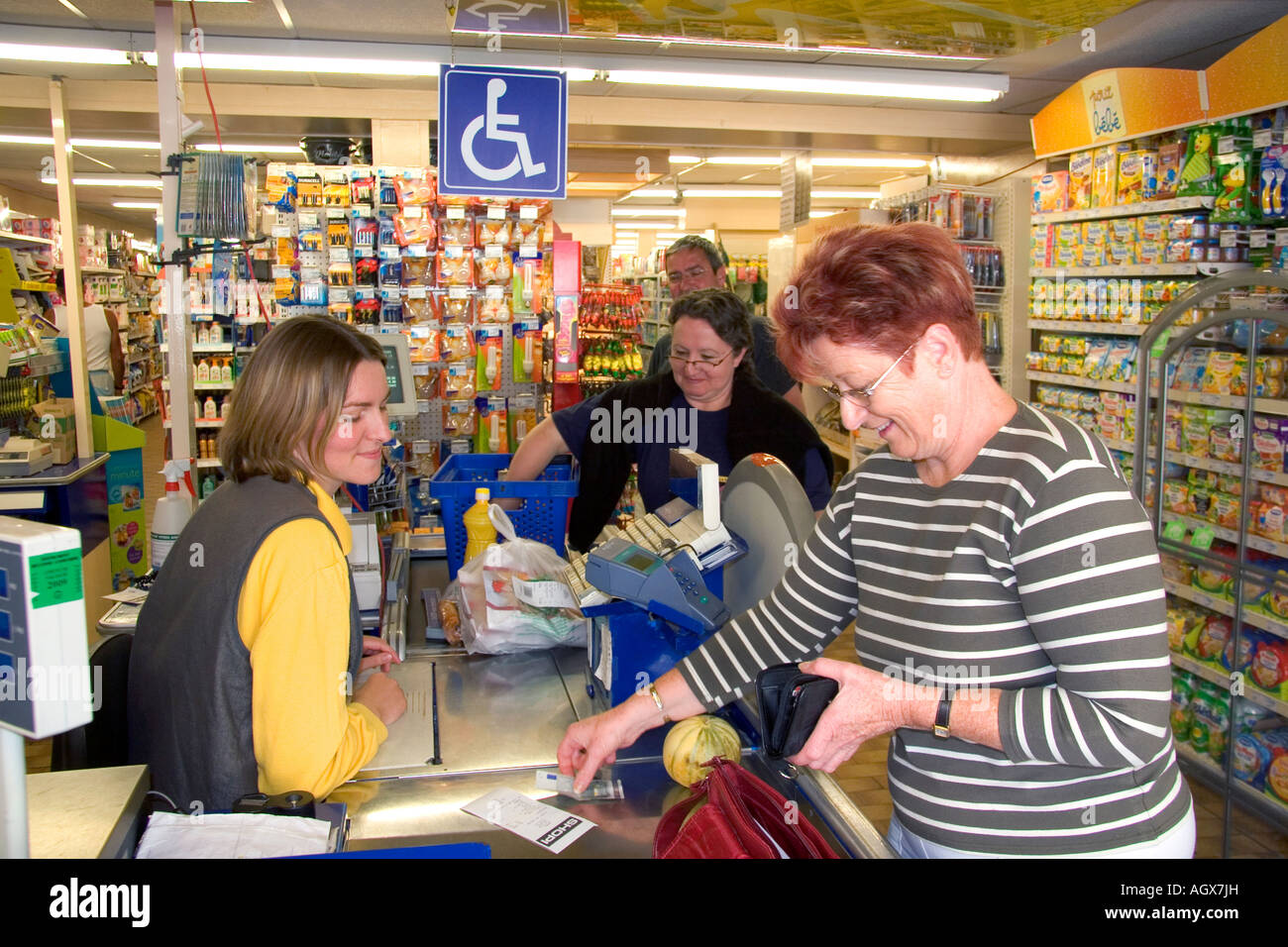 French woman pays for her groceries at a super market in the village of Barfleur in the region of Basse Normandie France Stock Photo