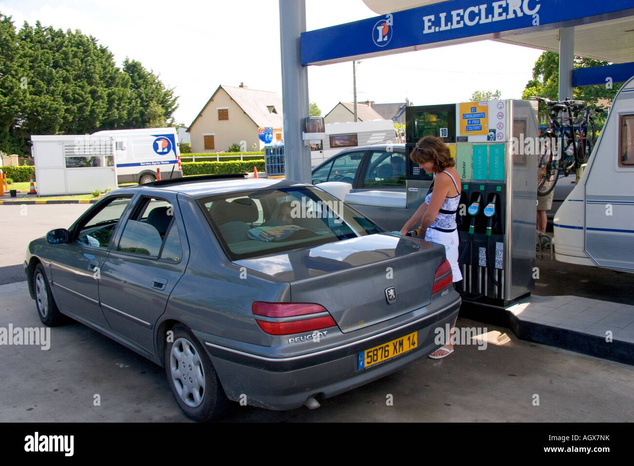A woman fueling up her car at a gas station in Bayeux in the region of Basse Normandie Normandy France Stock Photo