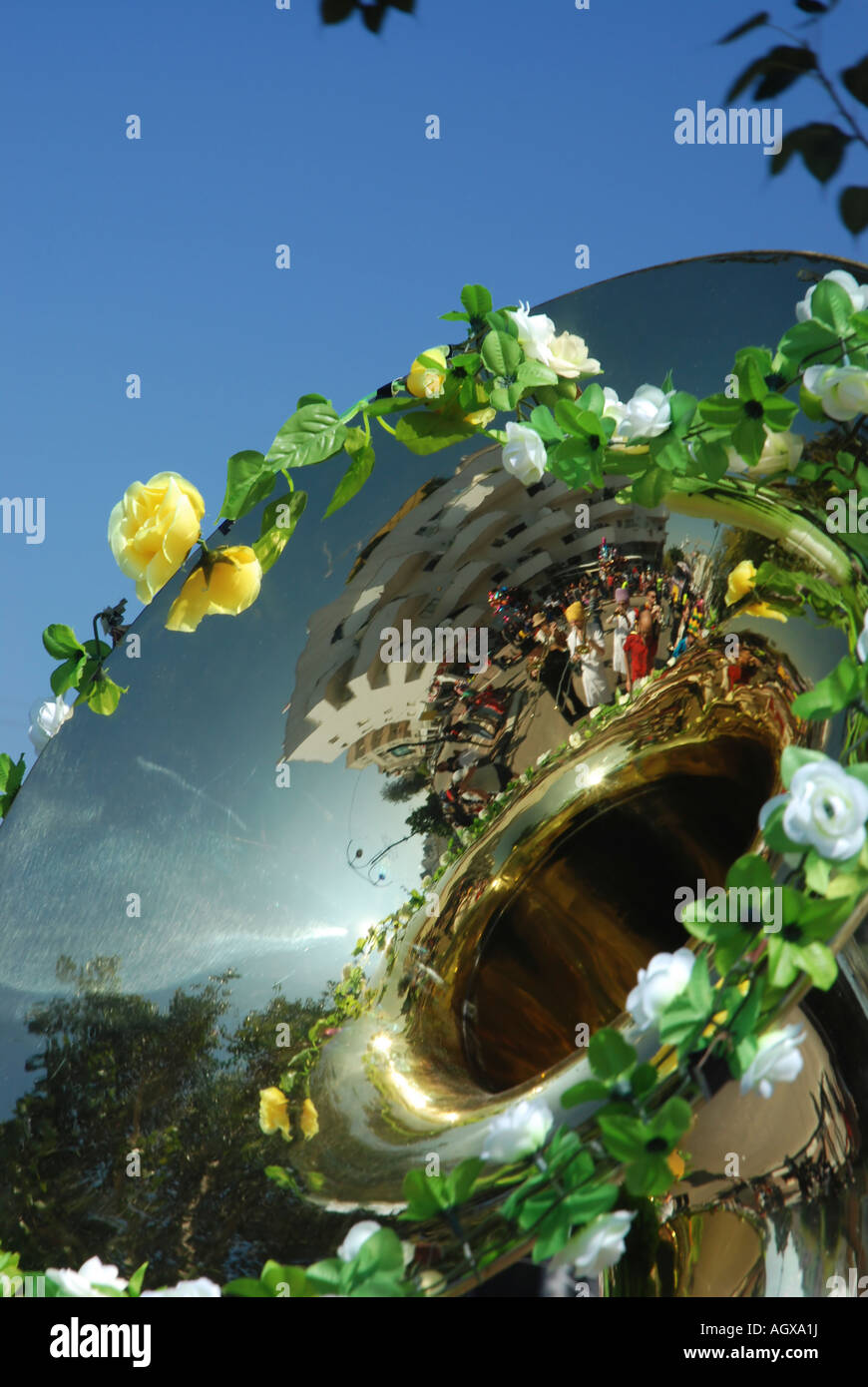 A tuba decorated with plastic flowers with a reflection of the marching band Stock Photo