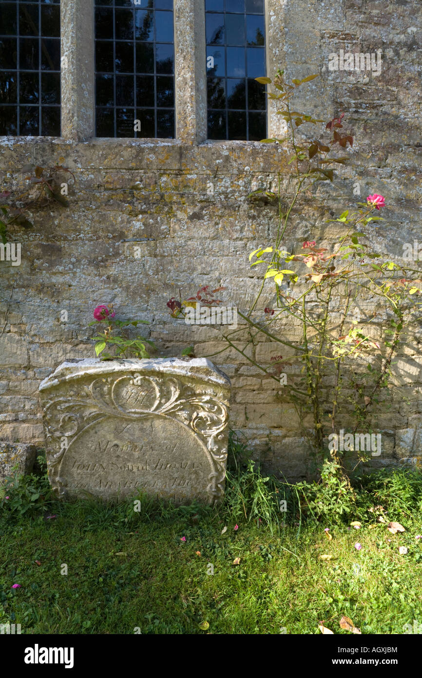 An old broken tombstone in the churchyard of Holy Rood church in the Cotswold village of Ampney Crucis, Gloucestershire Stock Photo