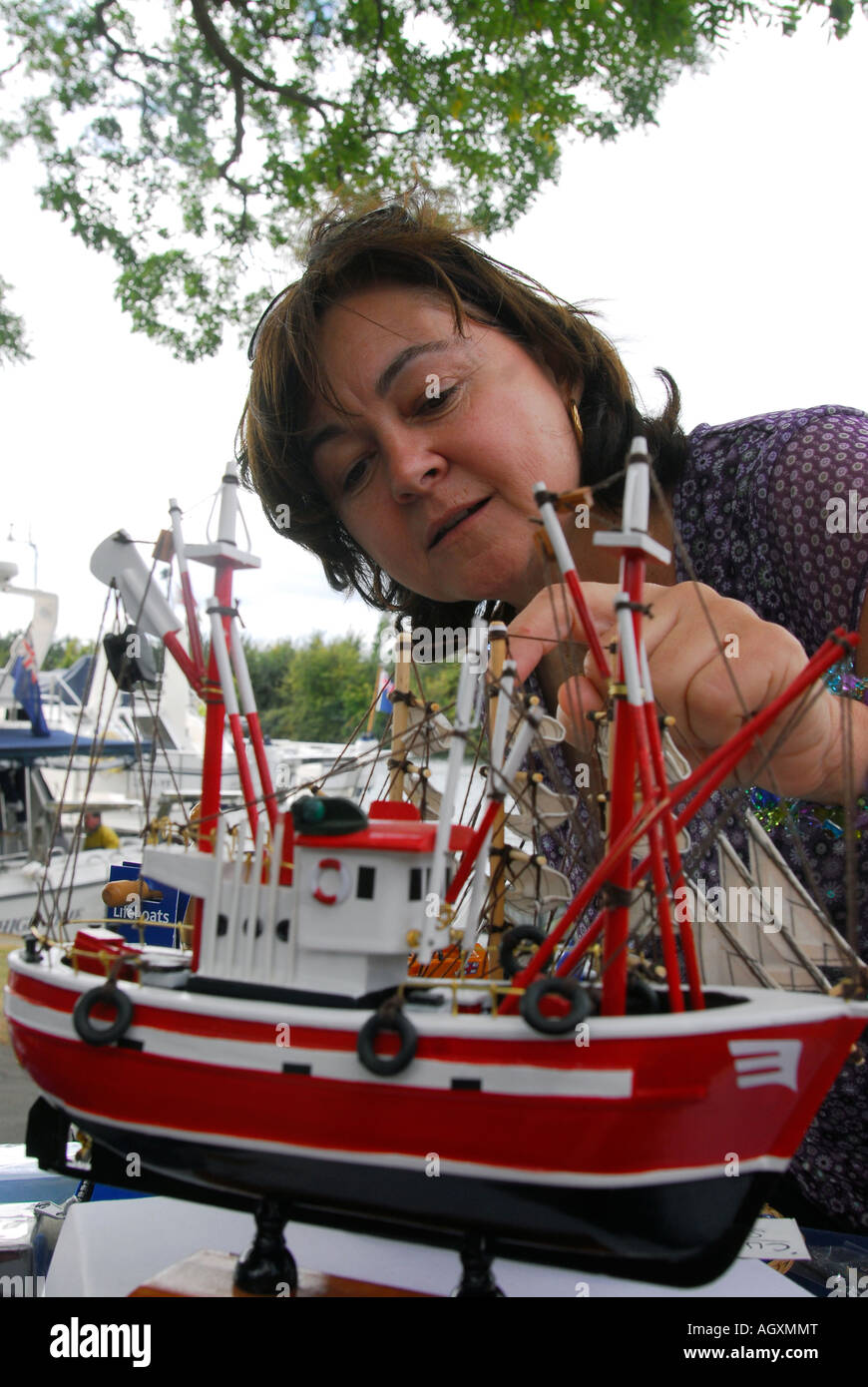 Woman examining model Lifeboat at a fundraising day, Surbiton, Surrey, UK. Stock Photo