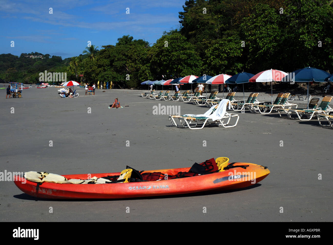 Beach with kayak, lawnchairs and umbrella sough of Quepos, entrance of Manuel Antonio National