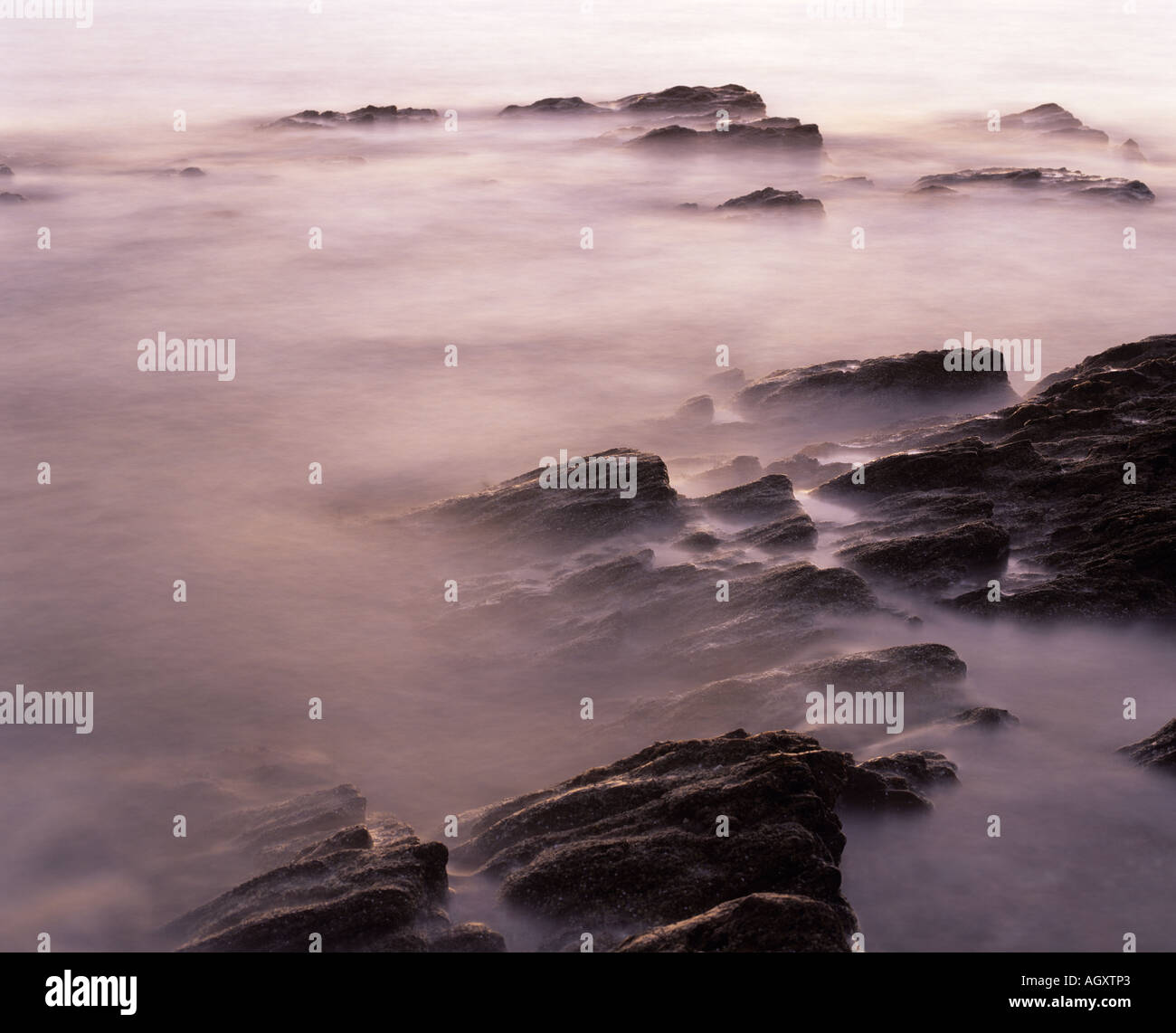 Rocky coast, blurred waves, Machrihanish Bay, Kintyre, Argyll, Scotland, UK Stock Photo