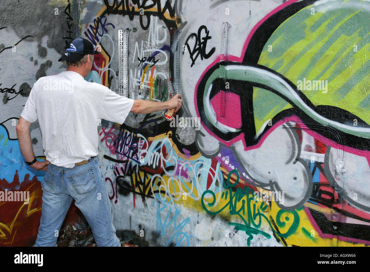 Man spraying graffiti on a wall Stock Photo