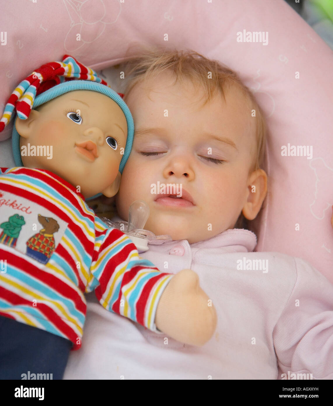 baby sleeping with doll in bed Stock Photo Alamy