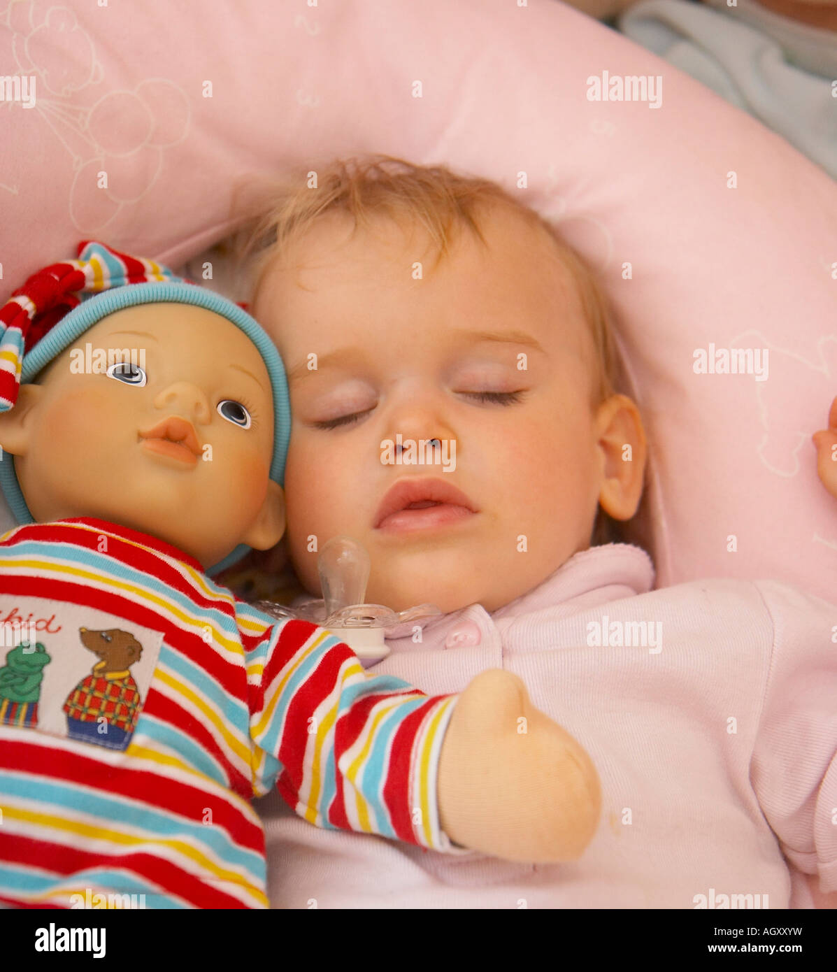 baby sleeping with doll in bed Stock Photo Alamy