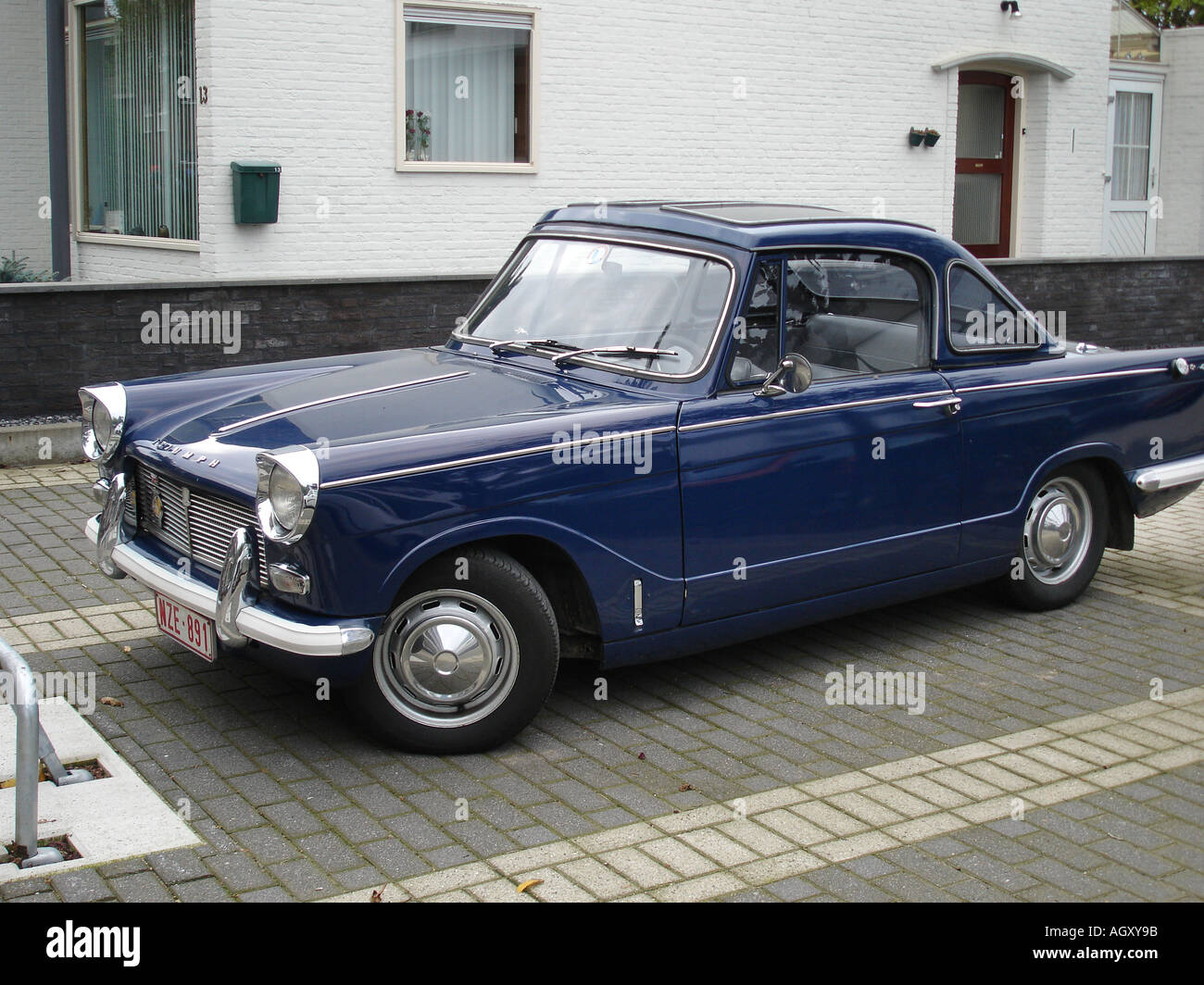 front three quarter view of dark blue Triumph Herald convertible parked by roadside Stock Photo