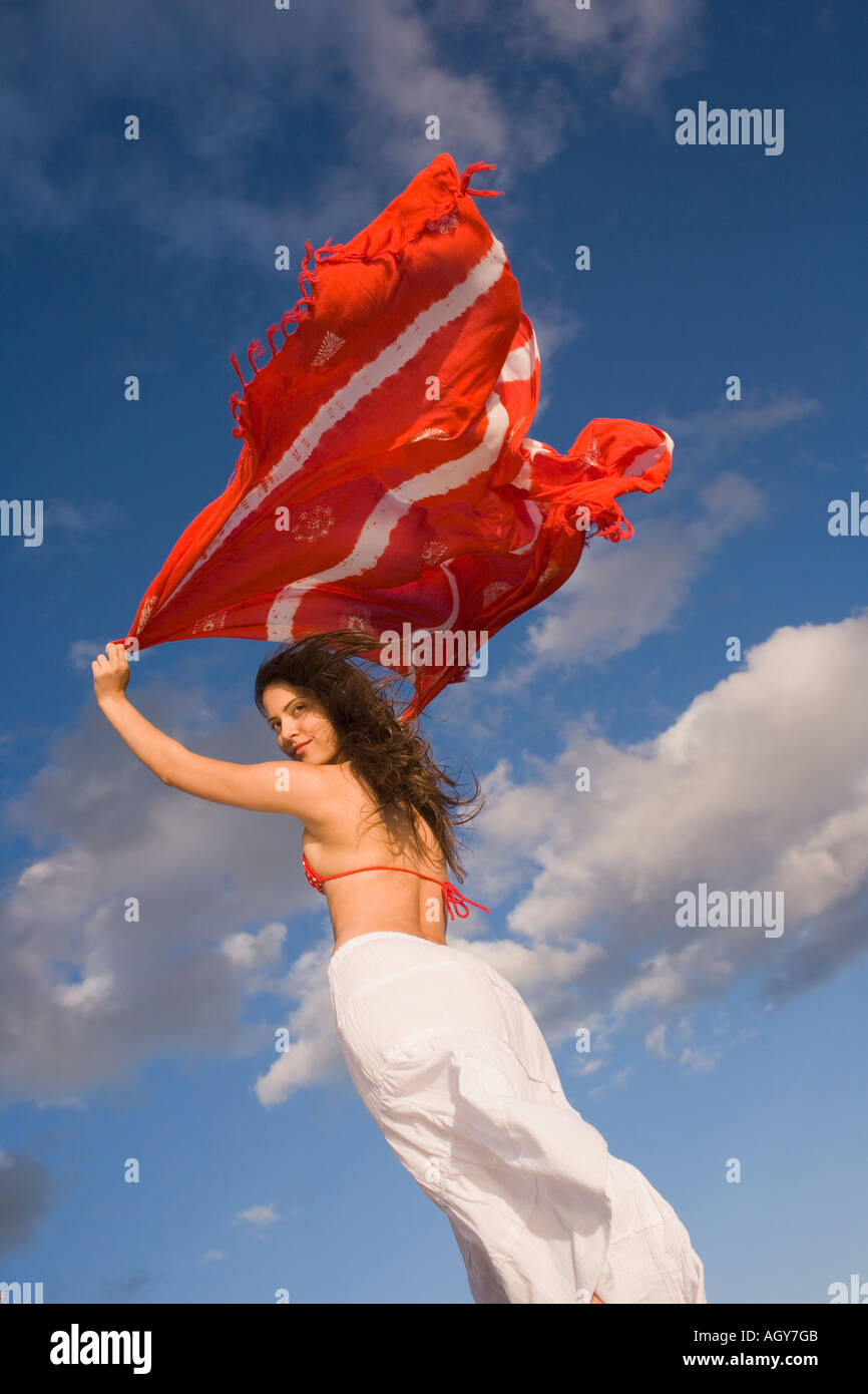 Young woman holding shawl over her head in the wind Stock Photo