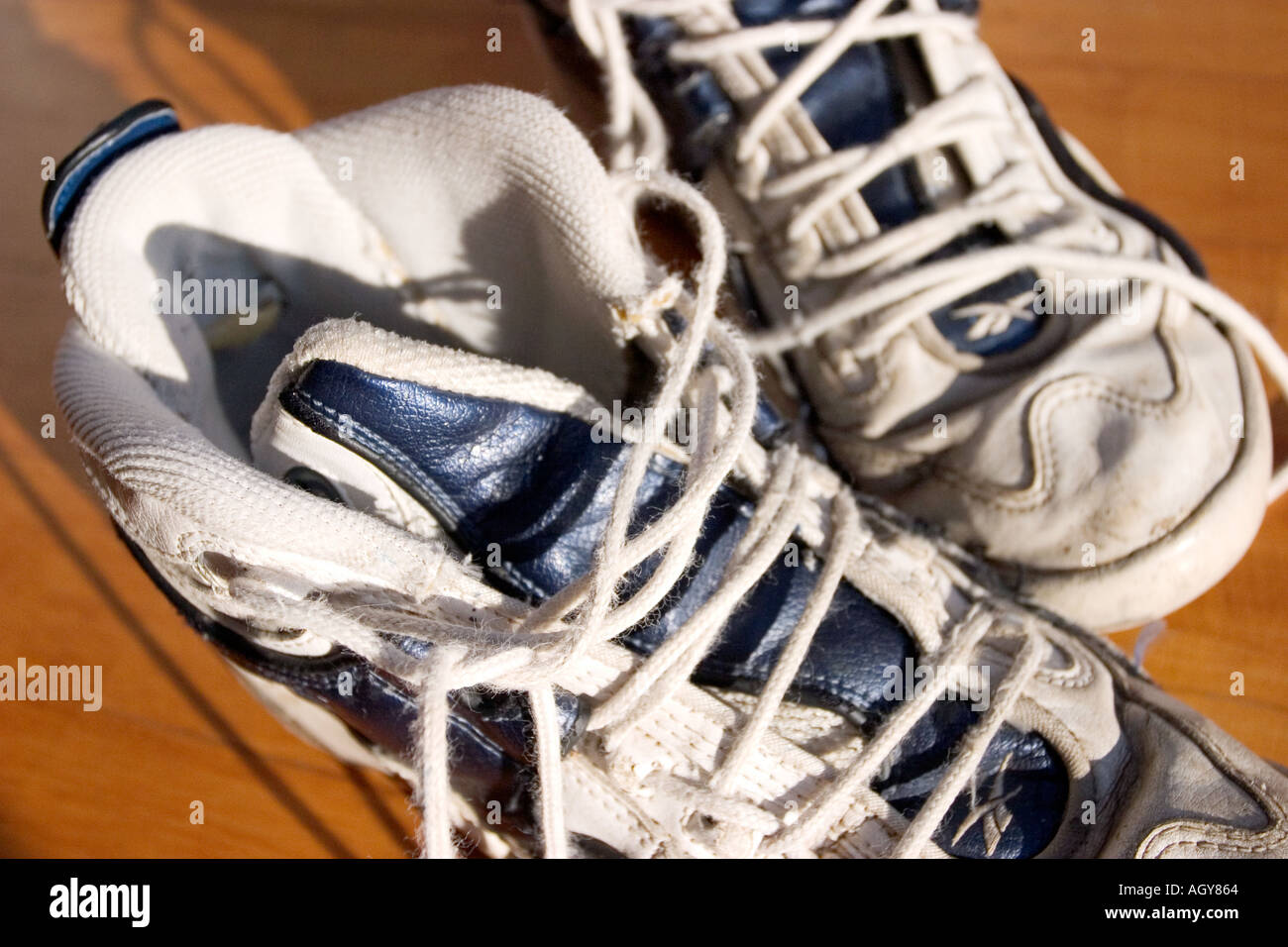 a pair of white tennis shoes with undone shoe laces sit next to each other Stock Photo Alamy