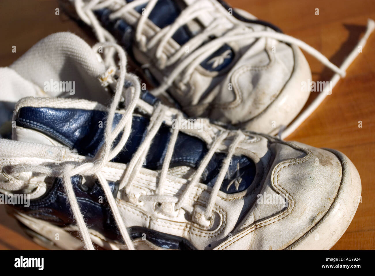 a pair of white tennis shoes with undone shoe laces sit next to each other Stock Photo Alamy