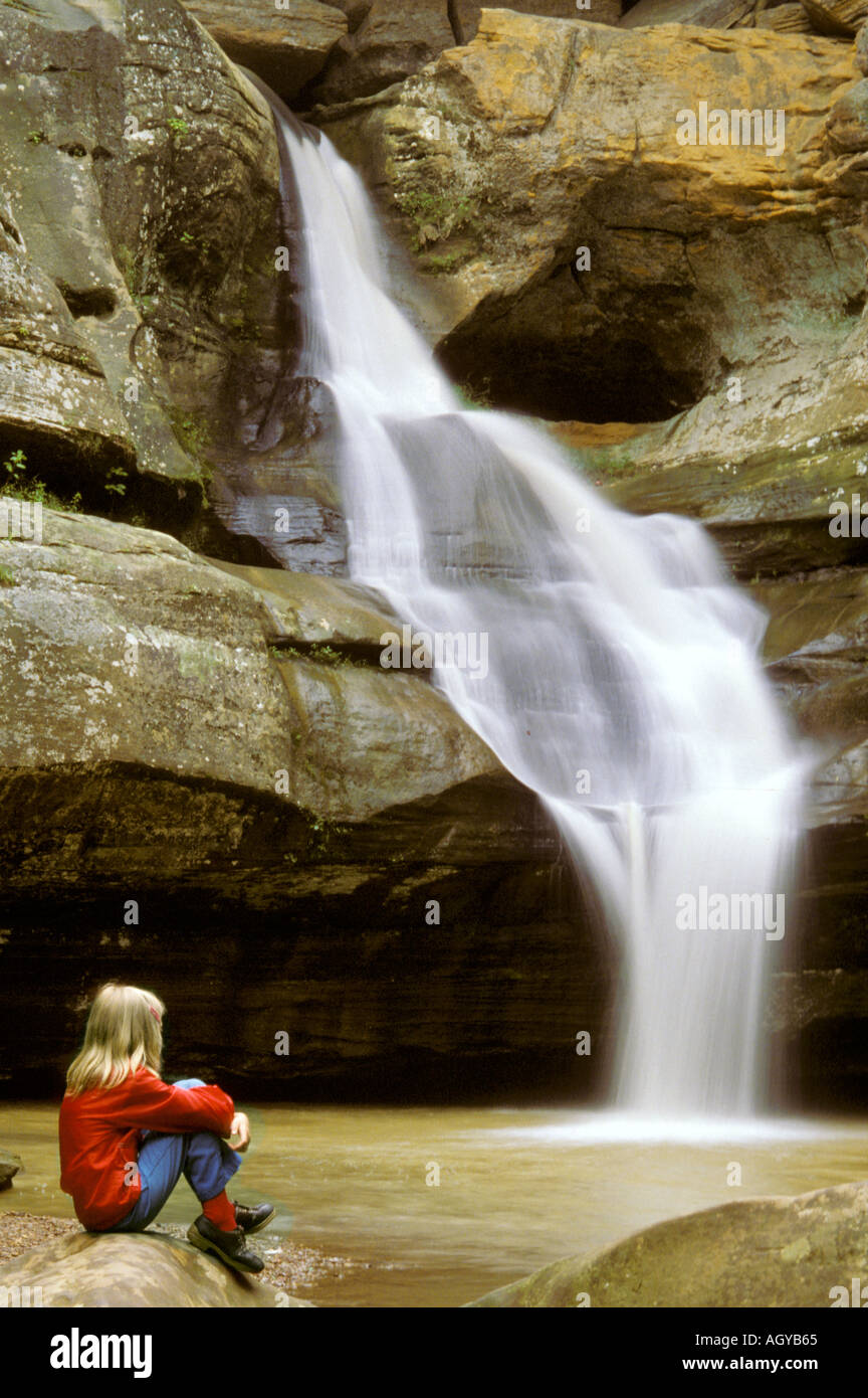 Little girl sits by Cedar water falls Hocking Hills State Park Ohio Stock Photo