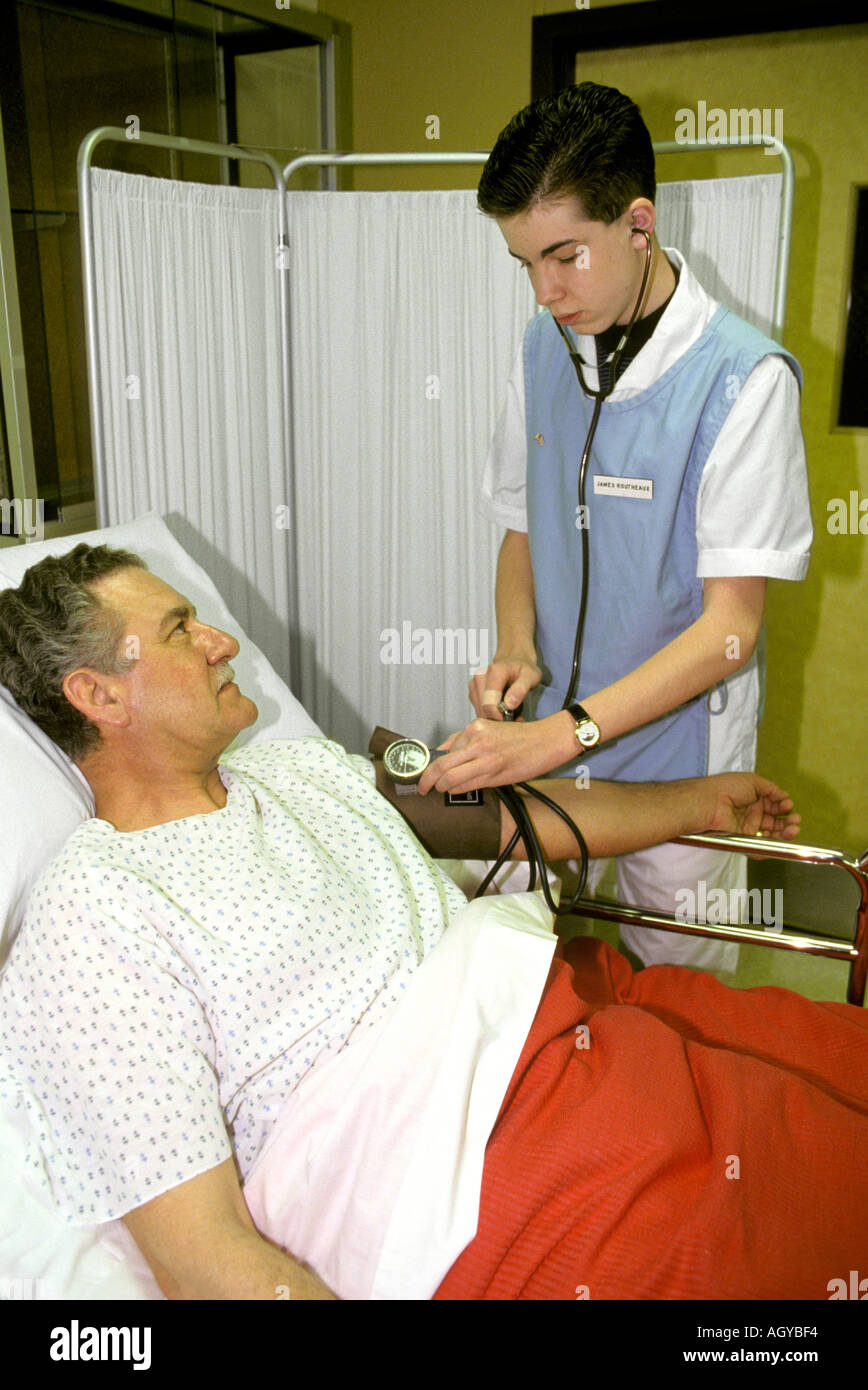 Student male nurse checks the blood pressure of a patient Stock Photo