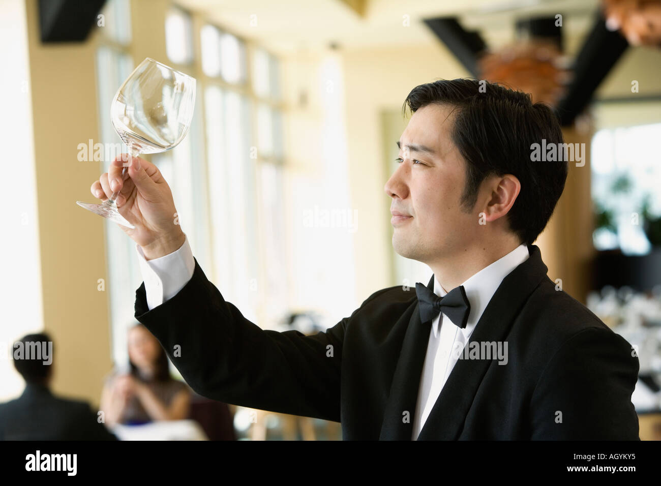 Upscale male waiter examining glass Stock Photo