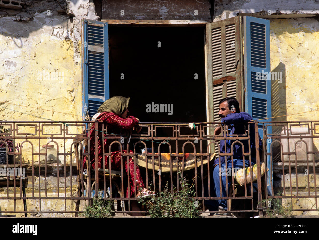 Couple having a coffee on the balcony of their half destroyed house located on the old green line in Beirut Lebanon Stock Photo