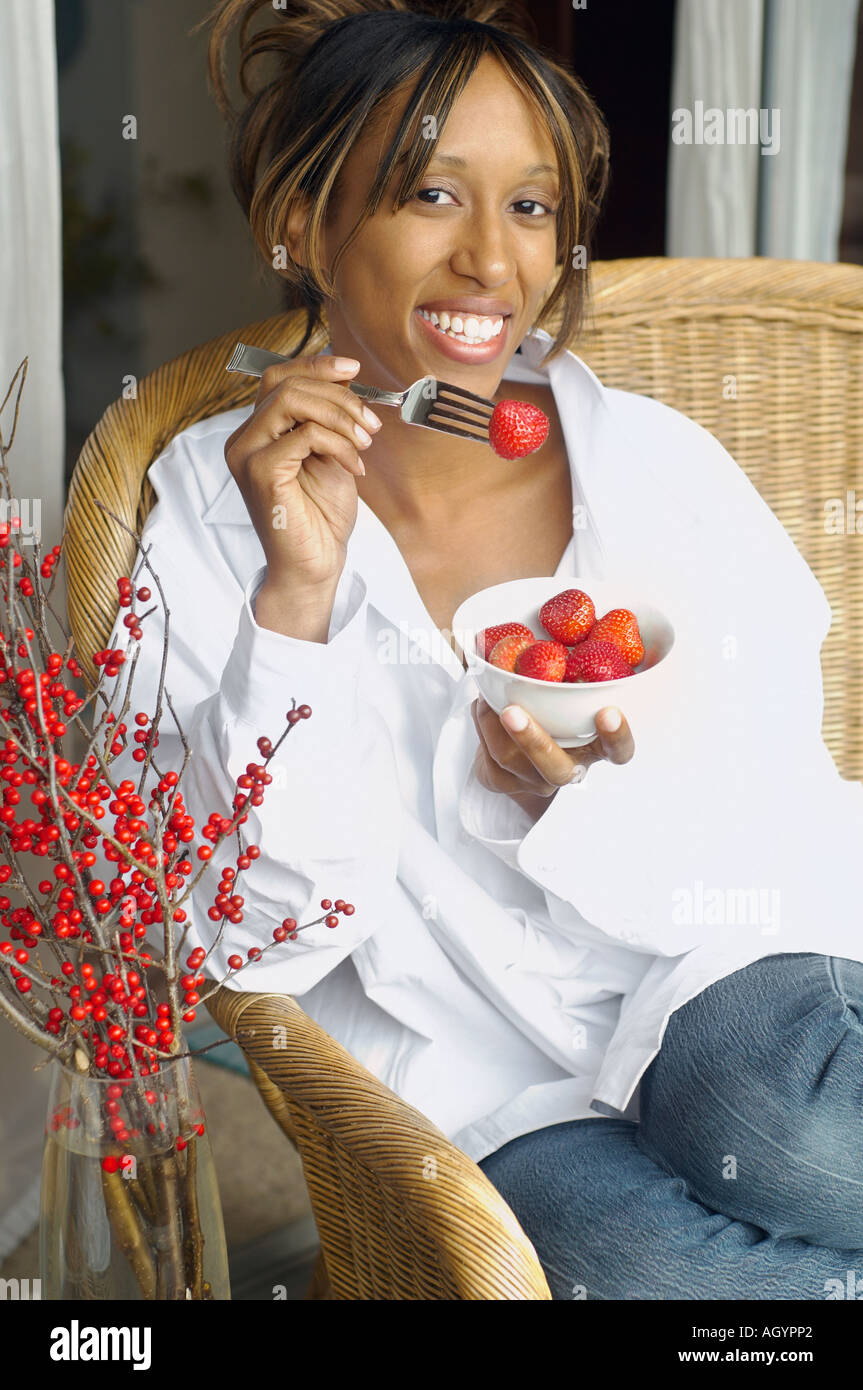 African American woman eating strawberries Stock Photo