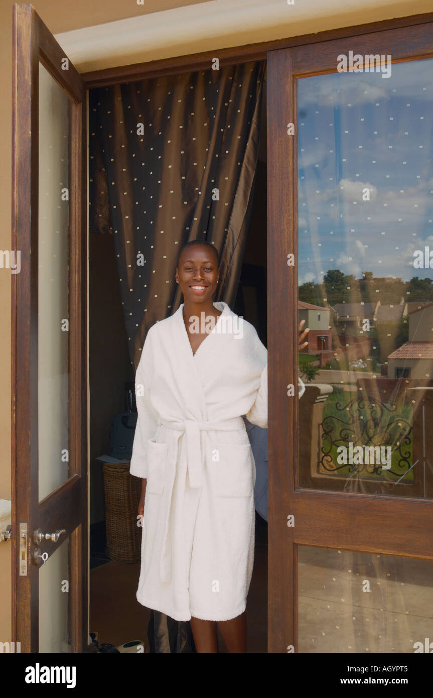 African American woman standing in doorway wearing hotel robe Stock Photo