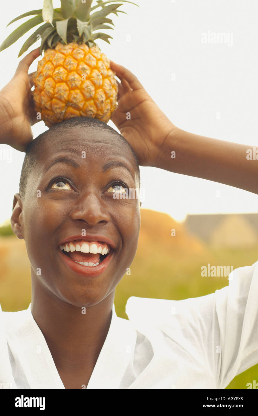 African American woman balancing pineapple on head Stock Photo Alamy