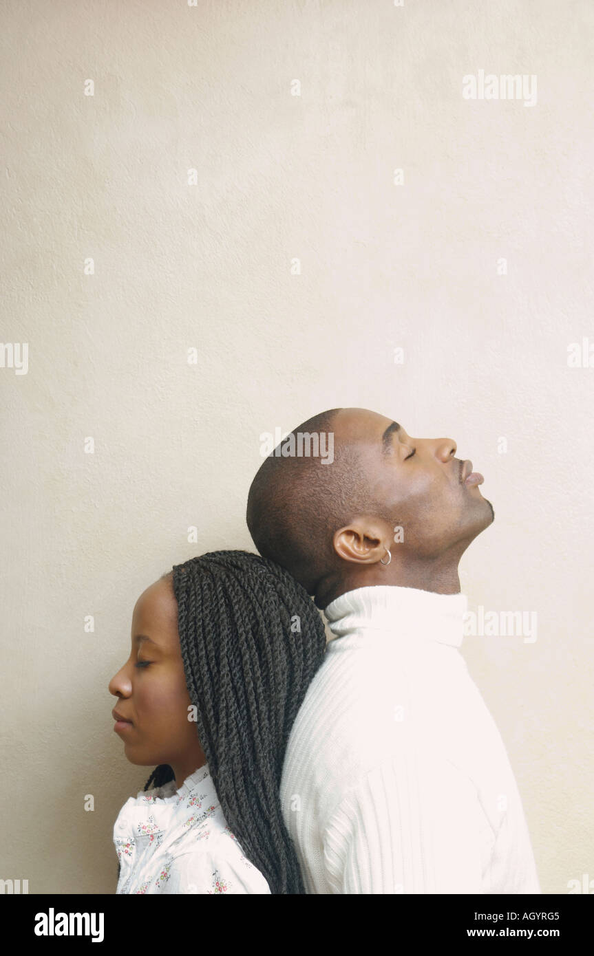 African American couple standing back to back with eyes closed Stock Photo