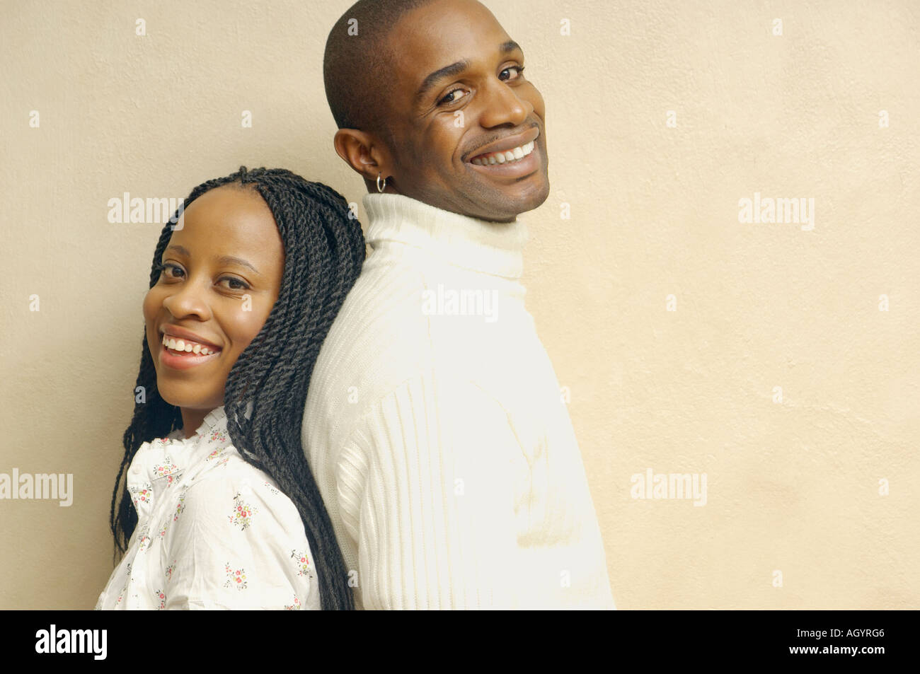 African American couple standing back to back smiling Stock Photo