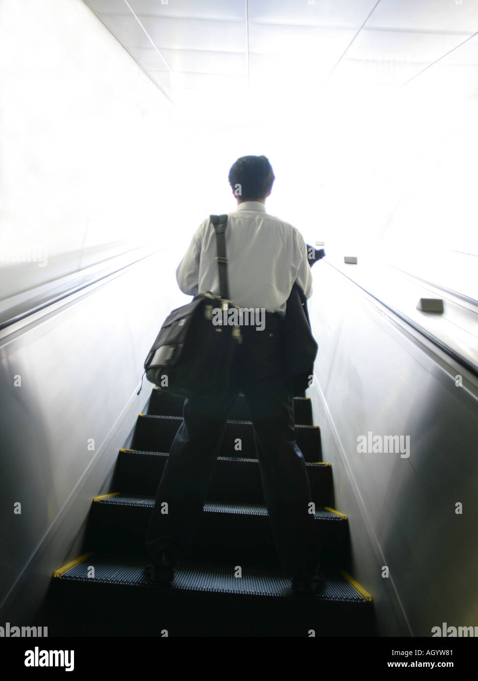 Rear view of a businessman standing on an escalator Stock Photo