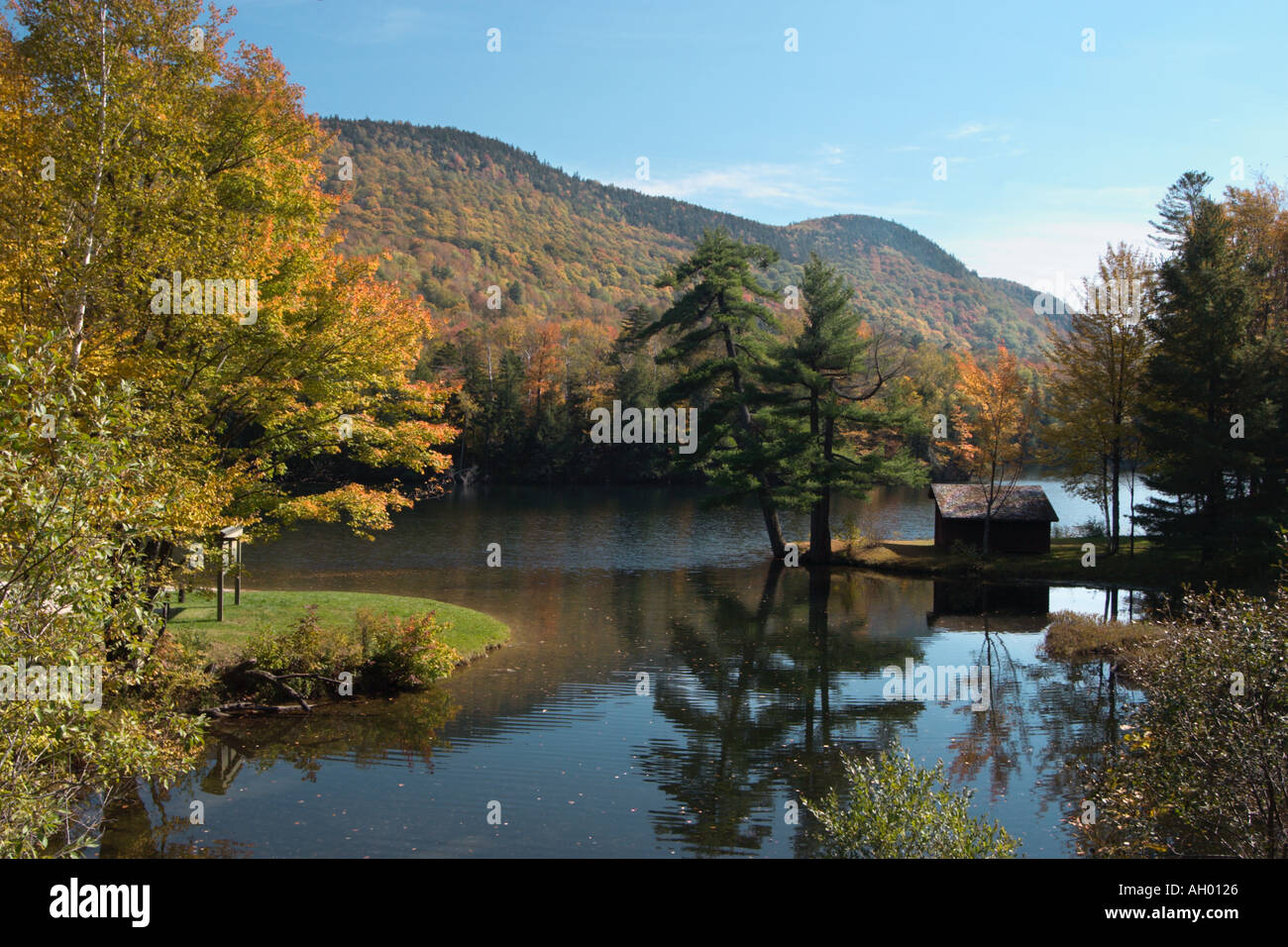 Log cabin on a quiet lake with fall foliage, off Highway 100, Green Mountains, Vermont, USA Stock Photo