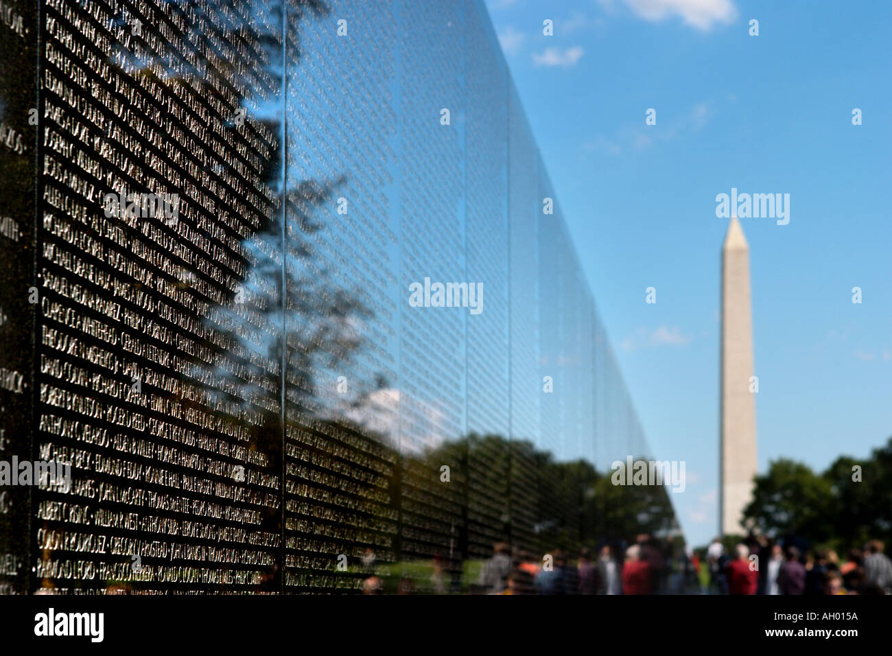 Names on the Vietnam Veterans Memorial with the Washington Monument in the distance, The Mall, Washington DC, USA Stock Photo