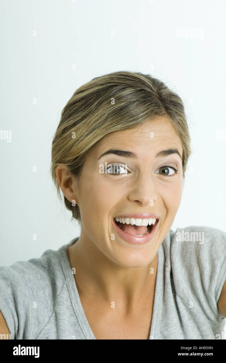 Young woman smiling and raising eyebrows, portrait Stock Photo
