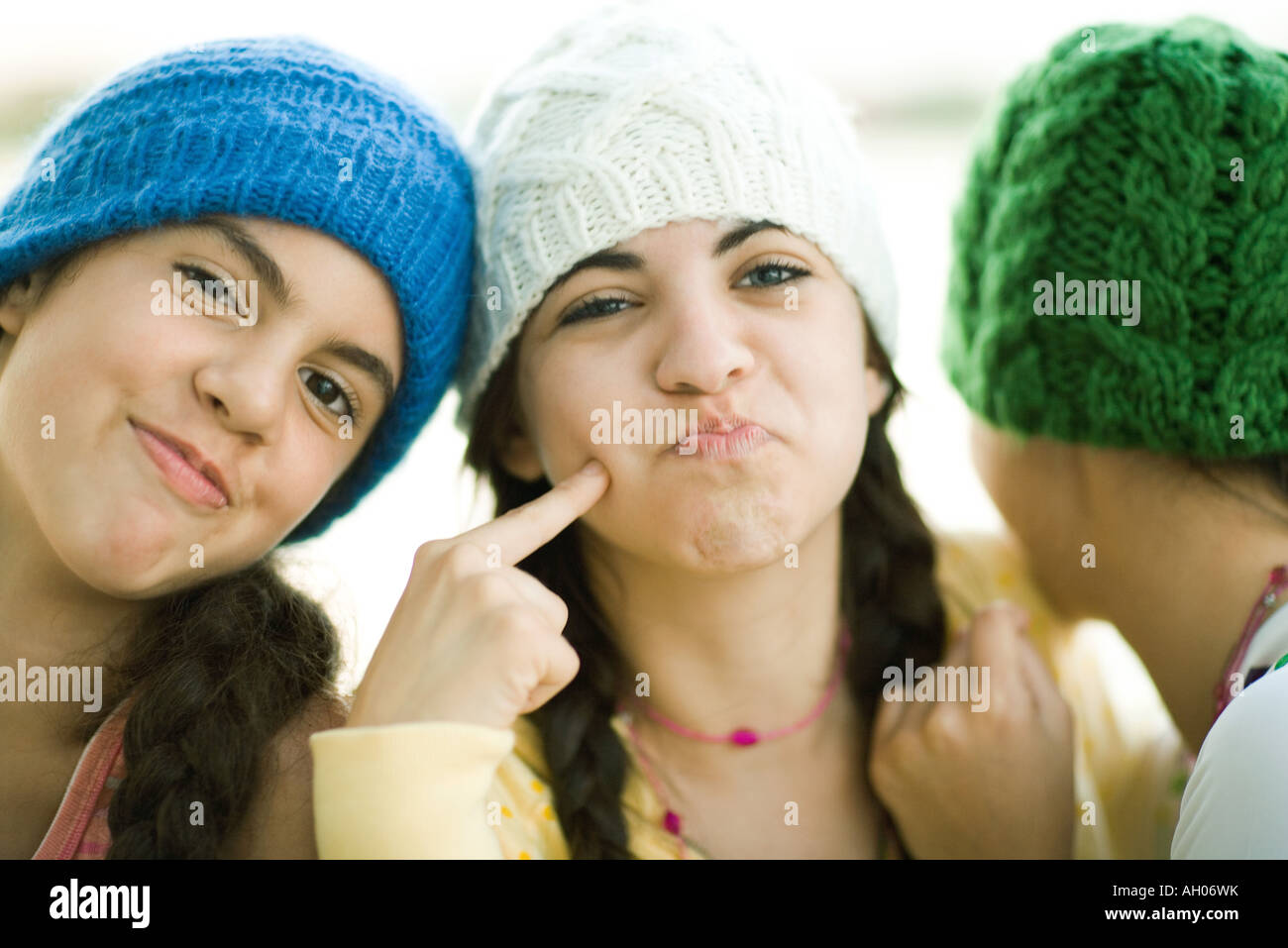 Young female friends wearing knit hats, making faces Stock Photo