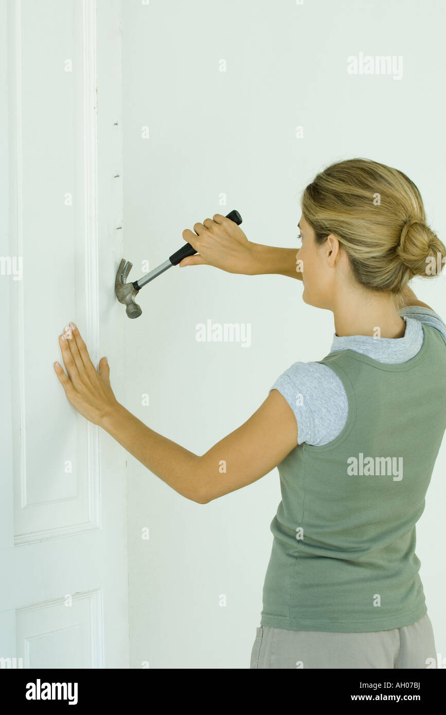 Woman removing nails with hammer Stock Photo Alamy