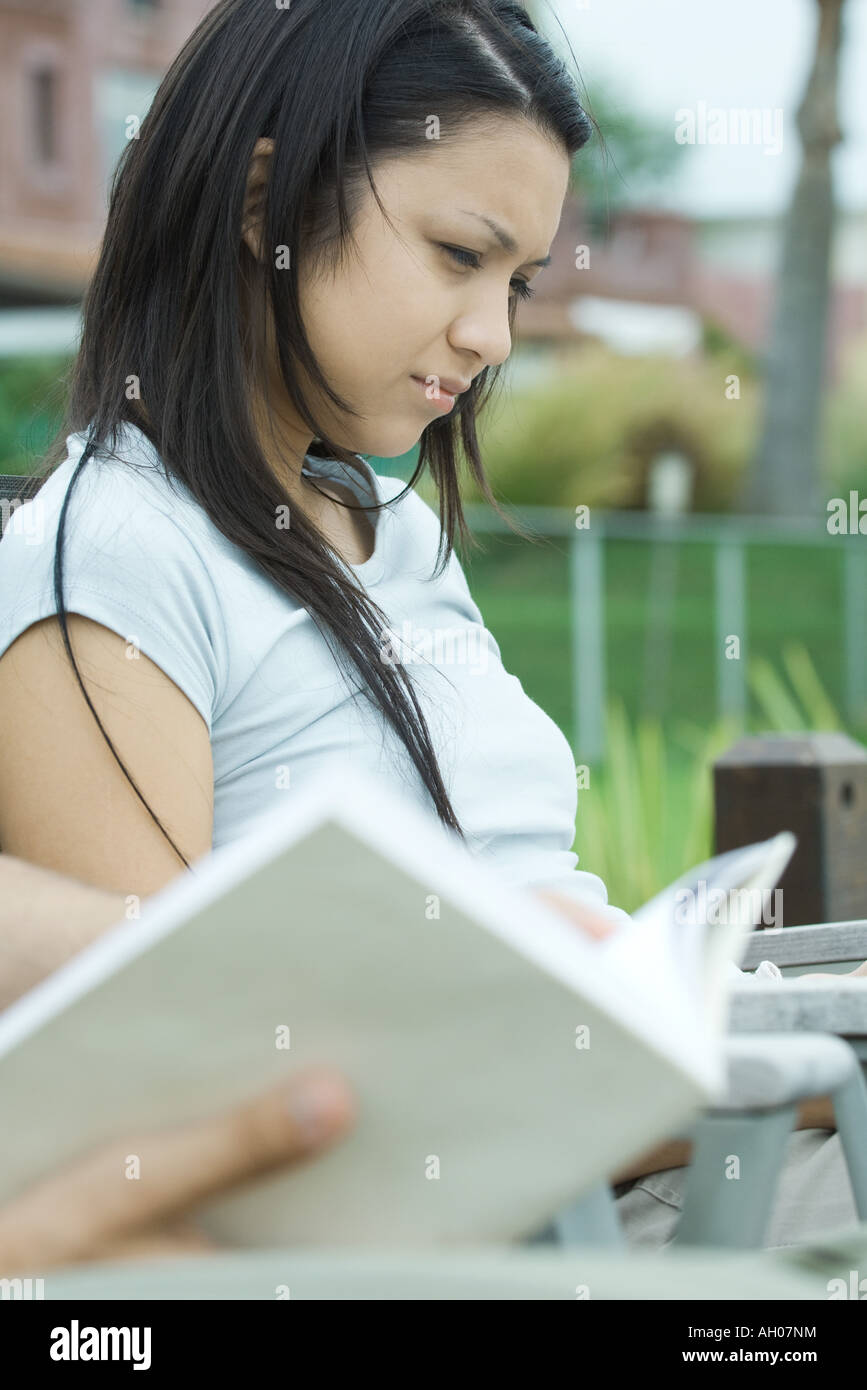 Young woman, book in blurred foreground Stock Photo