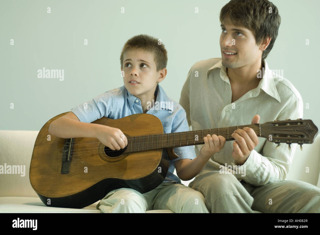 Man teaching boy to play the guitar Stock Photo
