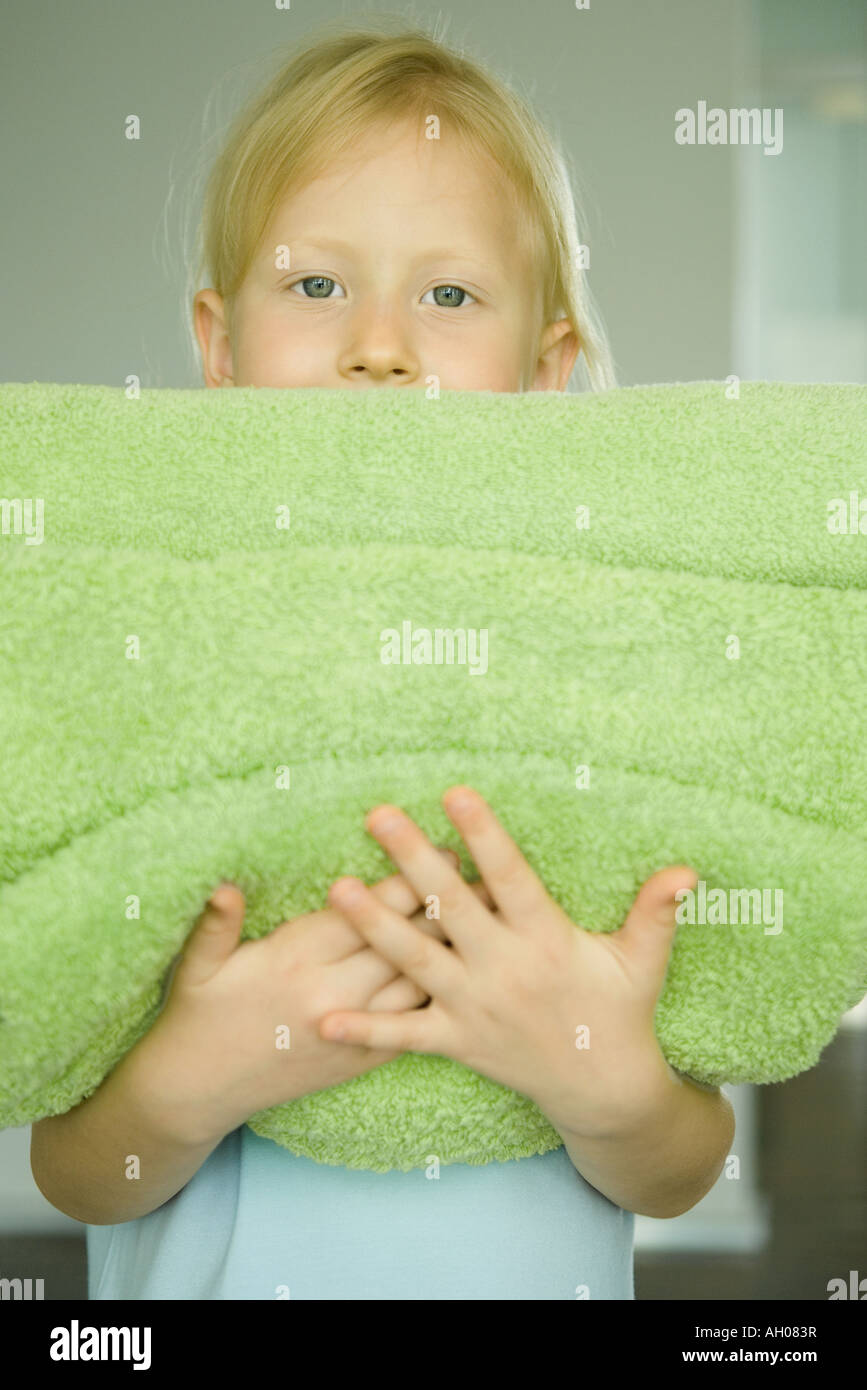 Girl holding stack of towels, portrait Stock Photo - Alamy